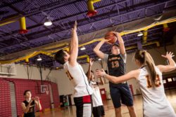 Students shooting basketball