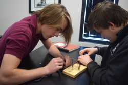 Two students working on a science experiment involving electricity.