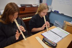 Two students playing recorder.