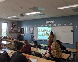 Spanish teacher stands at front and teaches class of high schoolers