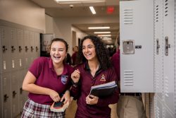 Two students standing at their lockers.