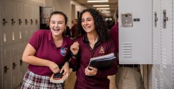 Two students standing at their lockers.